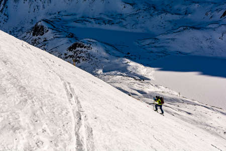 Bukowina Tatrzanska, Poland - January 12, 2020: The skier approaches skiing on a snowy slope. Winter mountain tourism. In the background a valley with frozen ponds visible. Ski touring.のeditorial素材