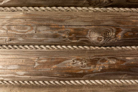 Old brown wall in a log building with horizontal logs and a rope. Traditional mountain style of building houses and huts in Podhale and Beskids in Poland.の写真素材