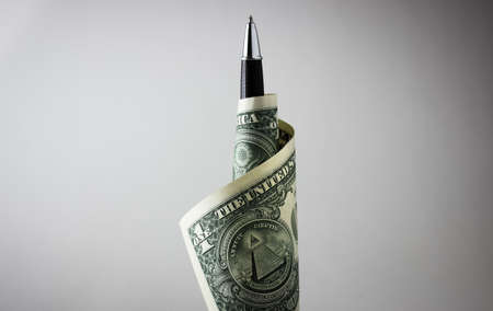 Pen wrapped in one dollar billの写真素材