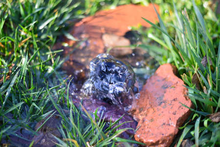 Flowing water through rocks and grassの写真素材