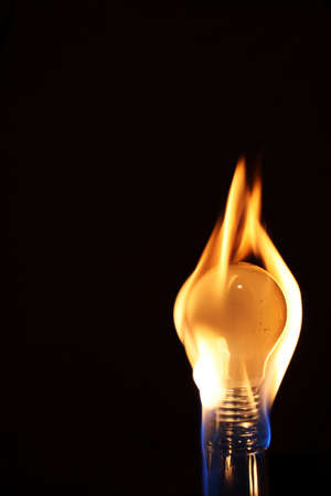 dark background. bulb in flames...の写真素材