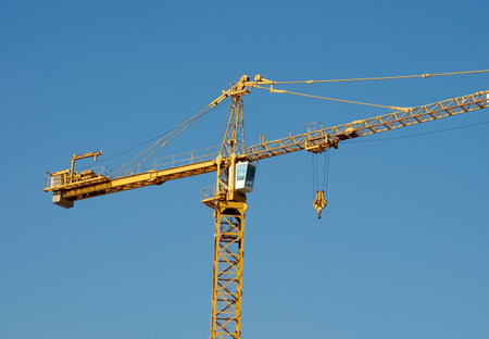 Yellow tower-crane under clair blue sky