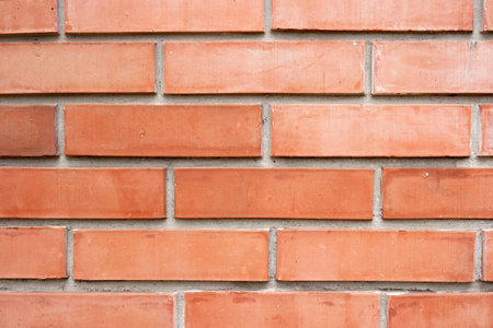 Regular reddish brick wall closeup