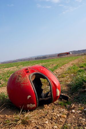 Abandoned red helmet in an agricultural areaの写真素材