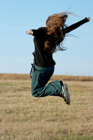 Jumping young girl with long hair in the air 