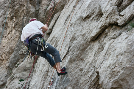 Rock climber coming down from the wallの写真素材