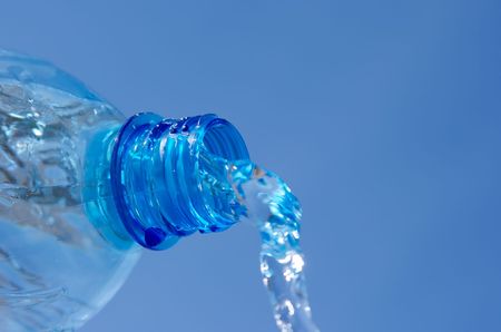 Mineral water flowing from a plastic bottleの写真素材