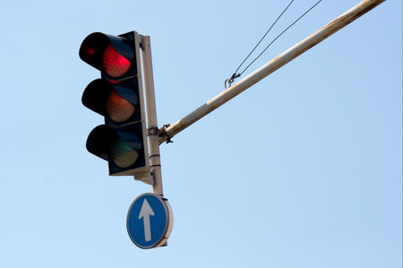 Red traffic light against clear blue sky
