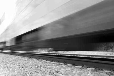 Train moving fast with motion blur. Black and white high-key image