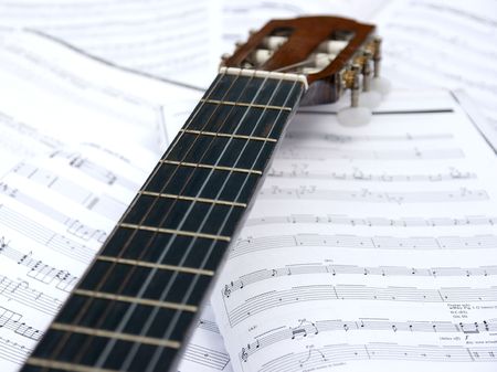 Acoustic guitar head and neck over sheet musicの写真素材