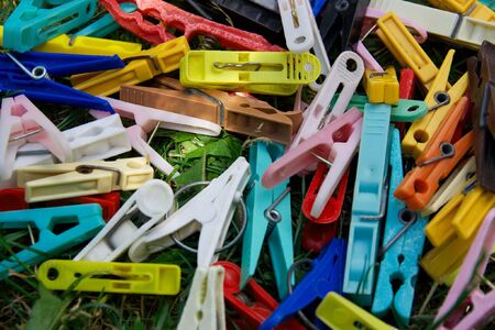 A pile of colorful clothes-pegs on the groundの写真素材