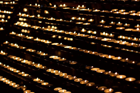 Rows of burning candles in a church