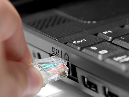 Network cable about to be plugged in a laptop