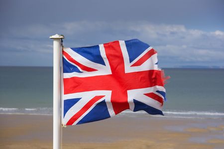 British flag fluttering in the wind on the shoreの写真素材