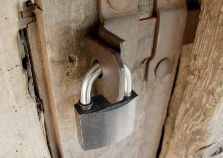 Padlock on an old wooden barn doorの写真素材