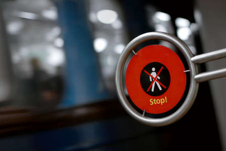 Warning sign far pedestrians with metro vehicle passing by with motion blurの写真素材