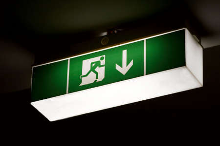Emergency exit sign glowing in the darkの写真素材
