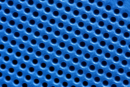 Hole pattern grid of an electronic device in blueの写真素材