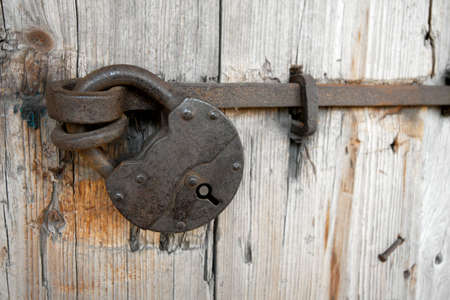 Old padlock on a wooden doorの写真素材