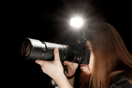 Photographer using DSLR camera with flash and telephoto lensの写真素材