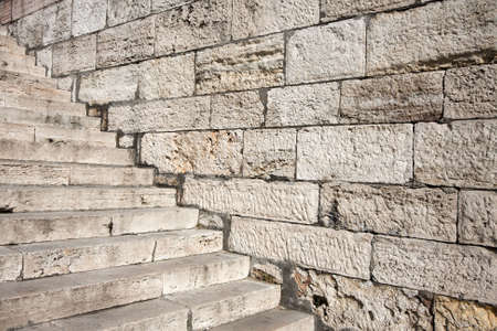 Old stone staircase and wall with rough textureの写真素材