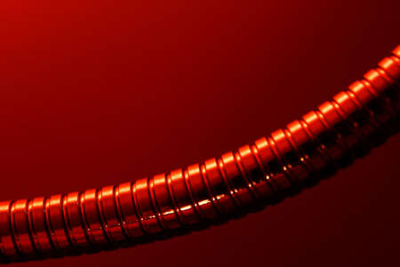 Shiny metal tube in red lightの写真素材