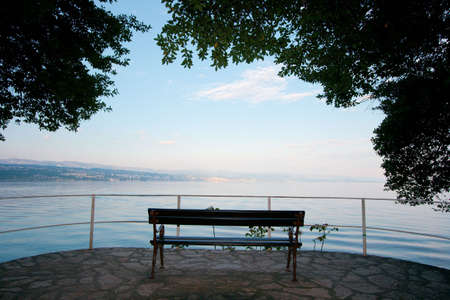Empty bench on the peaceful seashoreの写真素材