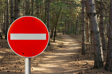 No entry sign in front of a forest path representing environmental protectionの写真素材