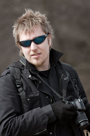 Portrait of a young man holding a camera