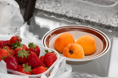 Peaches and strawberries on a tableの写真素材