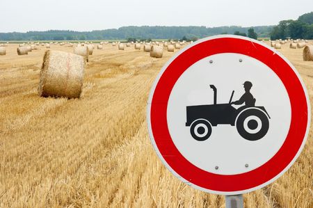 Tractor traffic sign in front of an agricultural fieldの写真素材