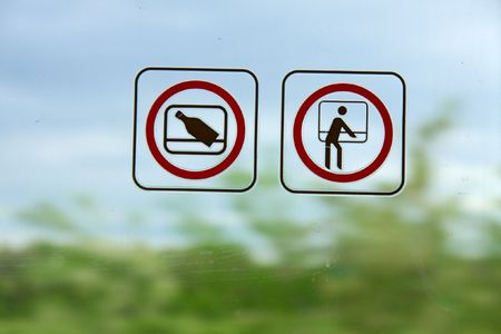 Signs on a train window prohibiting throwing out junk and leaning outの写真素材