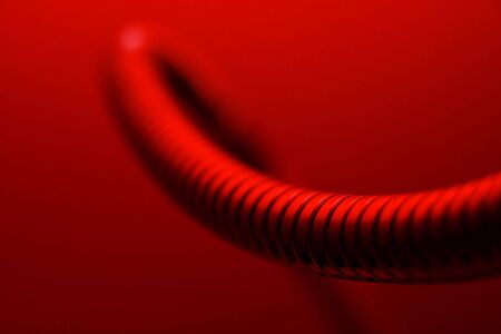 Abstract shape of a metallic tube in red lightの写真素材