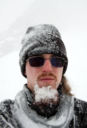 Portrait of a bearded man cover by snow in a blizzardの写真素材