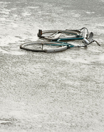 Abandoned, broken bicycle on a frozen lakeの写真素材
