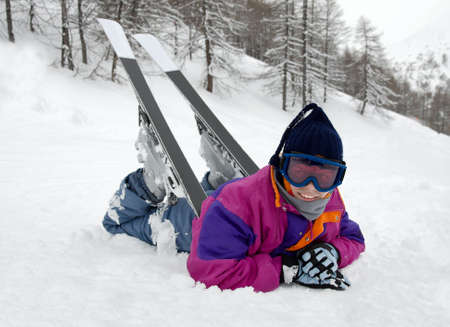 Young female skier resting on the snowの写真素材