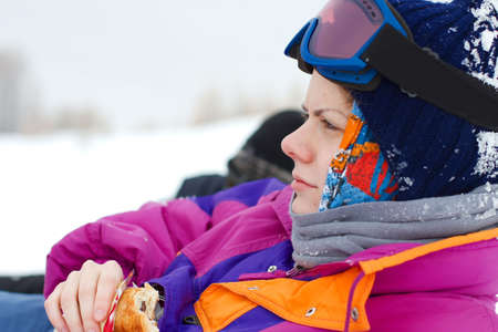 Young, female skier relaxing and eatingの写真素材