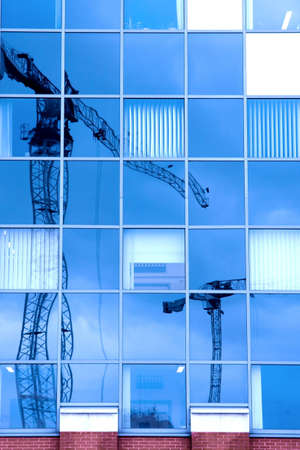 Reflection of a construction site in a glass office buildingの写真素材