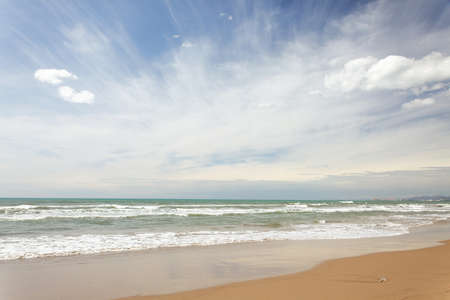 Sandy beach with waving seaの写真素材