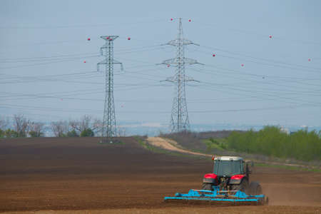 Tractor plowing the lands on an agricultural fieldの写真素材