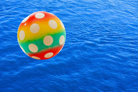 Colorful ball over blue water surfaceの写真素材