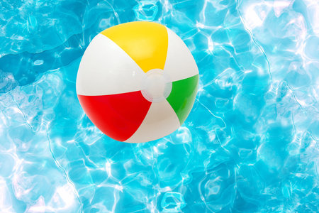 Beach ball over the water surface of a poolの写真素材