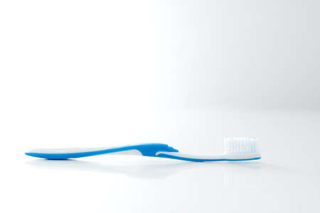 Toothbrush closeup on a white, reflective surfaceの写真素材