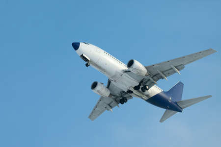 Landing plane against clear blue skyの写真素材