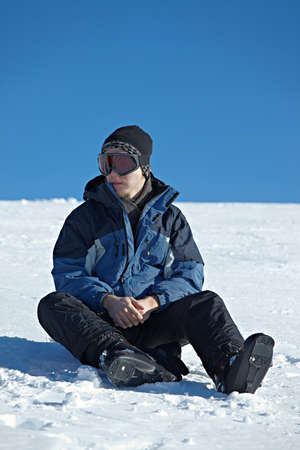 Skier resting sitting in the snowの写真素材