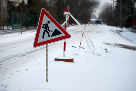 Road construction sign on a snowy streetの写真素材