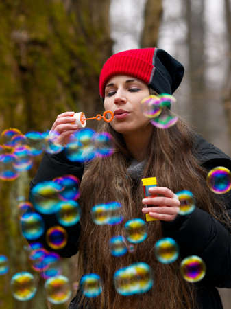 Woman blowing bubbles outdoorsの写真素材
