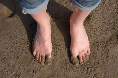Bare human feet in the sludgeの写真素材