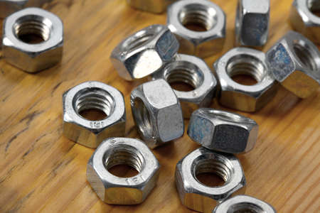 A pile of metal nuts on a tableの写真素材