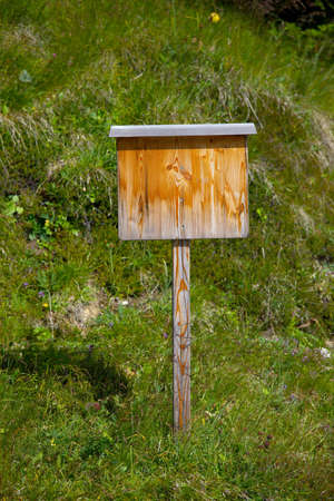 Empty, wooden signboard on an alpine meadowの写真素材